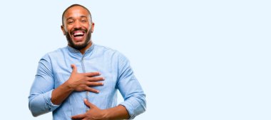 Kendinden emin ve mutlu ile mavi arka plan üzerinde izole gülüyor büyük bir doğal gülümseme sakallı Afrikalı-Amerikalı adam