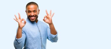 Meditasyon ve gevşeme mavi arka plan üzerinde izole ifade iki eliyle ok işareti jest yapıyor sakallı Afrikalı-Amerikalı adam