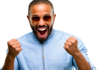 Mutlu ve heyecanlı kazanan jest ifade sakallı Afrikalı-Amerikalı adam. Beyaz arka plan üzerinde izole başarılı ve kutluyor zafer, muzaffer