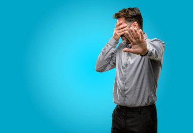 Baş, yorgun ve sinirli el orta yaş adam, sakal ve papyon stresli ve utangaç tutmak