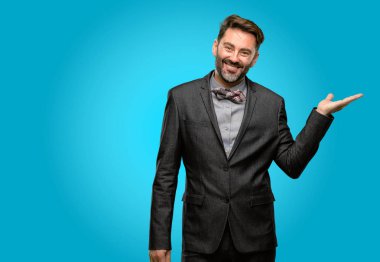 Orta yaş adam, sakal ve papyon bir şey boş elinde tutan