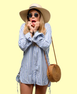 Güneş gözlüğü ve yaz şapka çok korkmuş ve sinir anksiyete ve panik jest, bunalmış ifade giyen genç kadın