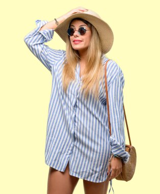 Genç kadın giyiyor güneş gözlüğü ve yaz şapka şüphe ifade, şaşırtmak ve kavramı, belirsiz gelecek merak ediyorum