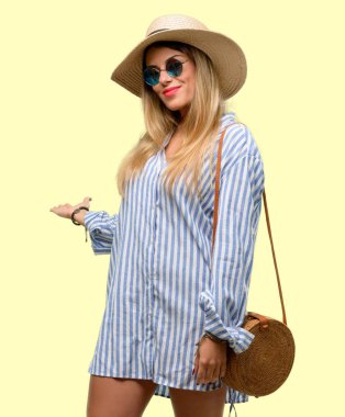 Güneş gözlüğü ve kendinden emin ve mutlu bir büyük doğal gülümseme davet ile girmek yaz şapka giyen genç kadın