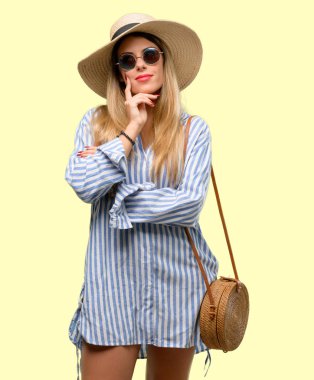 Güneş gözlüğü ve düşünme ve şüphe ve merak ifade arıyorum yaz şapka giyen genç kadın