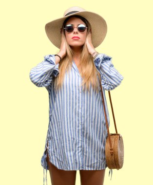 Güneş gözlüğü ve kulakları rahatsız edici gürültü, görmezden kapsayan yaz şapka giyen genç kadın takılan kulak işitme ses önlemek için. Gürültülü müzik bir sorundur.