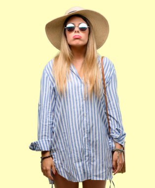 Güneş gözlüğü ve uykulu ifade, çok çalıştırılıyordu ve yorgun ile yaz şapka giyen genç kadın