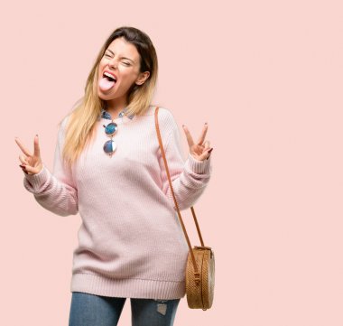 Genç Moda kadın parmakları tong ve verme zafer işaretiyle gösterilen kamera bakıyor