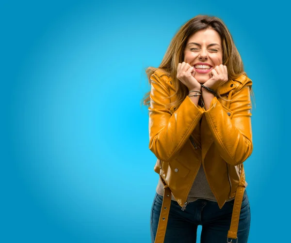 Beautiful young woman confident and happy with a big natural smile laughing, blue background