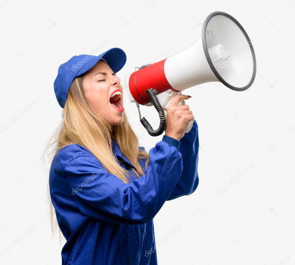 Young plumber woman communicates shouting loud holding a megaphone, expressing success and positive concept, idea for marketing or sales