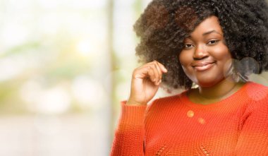 Güzel Afrikalı kadın kendinden emin ve mutlu gülüyor, açık büyük bir doğal gülümseme ile