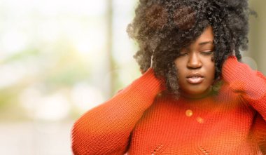 Kulakları rahatsız edici gürültü, görmezden kapsayan güzel Afrikalı kadın takılan kulak işitme ses önlemek için. Gürültülü müzik sorun var., açık olduğunu