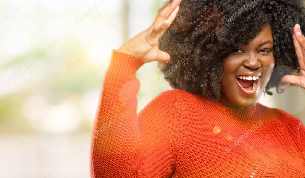 Beautiful african woman happy and surprised cheering expressing wow gesture, outdoor
