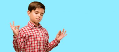 Meditasyon ve gevşeme mavi arka plan üzerinde ifade iki eliyle ok işareti jest yapıyor yeşil gözlü yakışıklı yürümeye başlayan çocuk