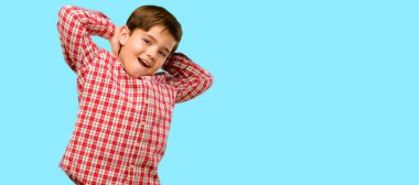 Kendinden emin ve mutlu ile mavi arka plan üzerinde gülüyor büyük bir doğal gülümseme yeşil gözlü yakışıklı yürümeye başlayan çocuk