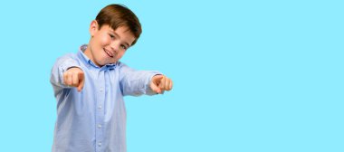 Mavi arka plan üzerinde açık parmak ile işaret eden yeşil gözlü yakışıklı yürümeye başlayan çocuk