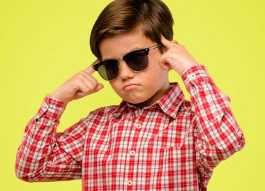 Yeşil gözlü yakışıklı yürümeye başlayan çocuk ifade şüphe, şaşırtmak ve kavramı, sarı arka plan üzerinde belirsiz gelecek merak ediyorum