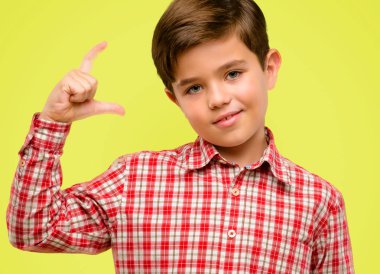 Yakışıklı yürümeye başlayan çocuk boyutu kavram sarı arka plan üzerinde çok küçük bir şey, holding yeşil gözlü