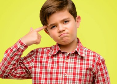 Mutsuz yeşil gözlü yakışıklı yürümeye başlayan çocuk intihar jest yapmak her şeyi yorgun. Sürgünler silah, sarı arka plan üzerinde üzgün taklit el ile