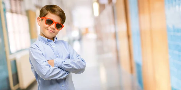 英俊的孩子与绿色的眼睛与交叉双臂自信和快乐的大自然微笑在学校走廊上笑 — 图库照片