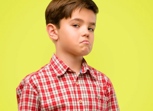 黄色の背景に対する不信感 懐疑論および疑いを表現する懐疑的と不満の顔を持つ緑の目を持つハンサムな幼児児童 — ストック写真