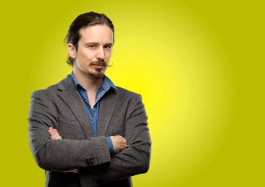 Kendinden emin ve mutlu bir büyük doğal gülümseme gülmek ile çapraz kollu yakışıklı genç