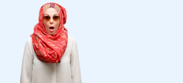中年ヒジャーブを身に着けているアラブのイスラム教徒の女性を怖がって ショックでパニックと恐怖を表現する分離された青色の背景 — ストック写真