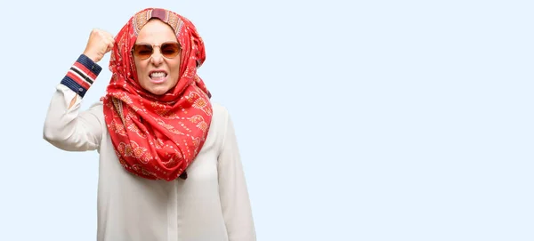 中年イスラム教徒アラブ女性着用ヒジャーブのイライラと怒っている否定的な感情を表現する分離の青い背景誰かと悩まされて — ストック写真