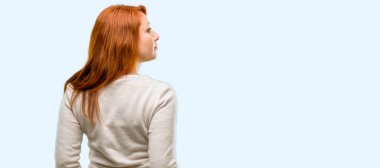 Güzel genç Kızıl saçlı kadın arka, dikiz mavi arka plan izole