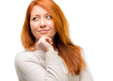 Soru ve şüphe ifade etmek acımak yüz ile düşünceli düşünme güzel genç Kızıl saçlı bir kadın. Beyaz arka plan üzerinde izole çözüm düşünün