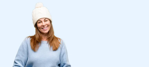 分離の青い背景を笑いながら自然な笑顔で自信を持って 幸せのウール冬帽をかぶって中年女性 — ストック写真