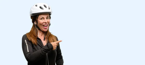 Middle Age Cyclist Woman Using Earphones Pointing Away Side Finger — Stock Photo, Image