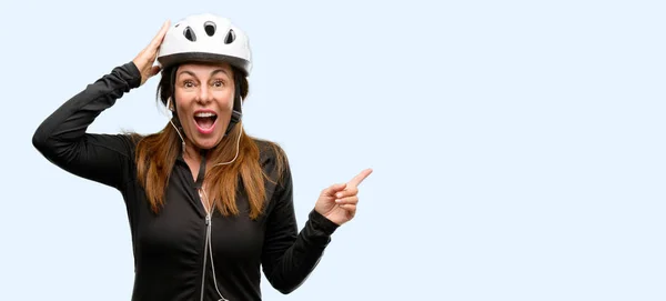 Middle Age Cyclist Woman Using Earphones Pointing Away Side Finger — Stock Photo, Image