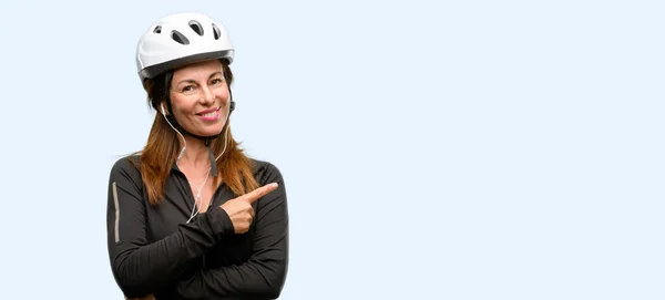 Middle Age Cyclist Woman Using Earphones Pointing Away Side Finger — Stock Photo, Image