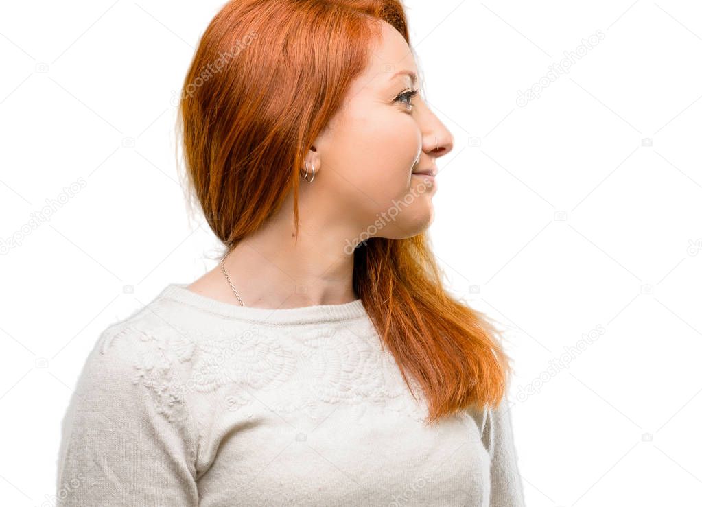 Beautiful young redhead woman side view portrait isolated over white background