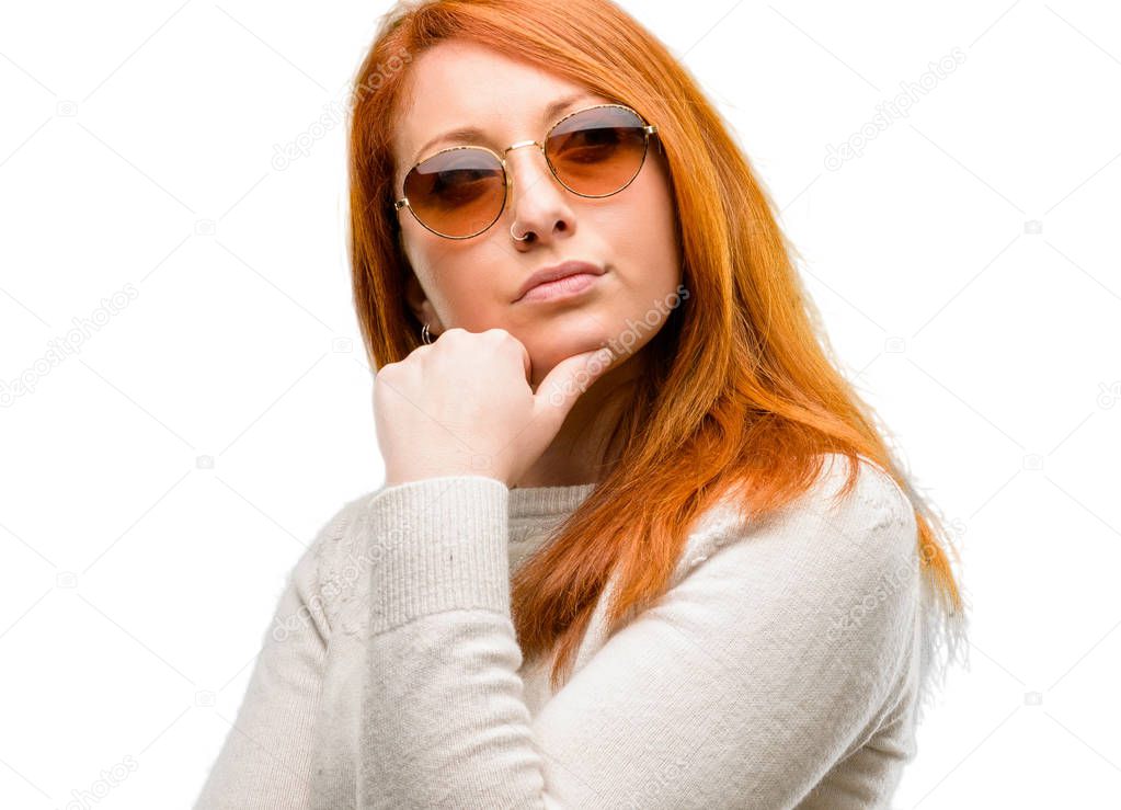 Beautiful young redhead woman doubt expression, confuse and wonder concept, uncertain future isolated over white background