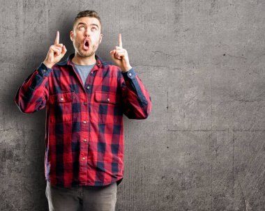 Genç yakışıklı adam mutlu ve yukarı dönük ifade wow jest tezahürat