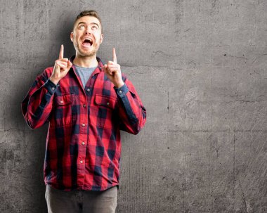 Genç yakışıklı adam mutlu ve yukarı dönük ifade wow jest tezahürat