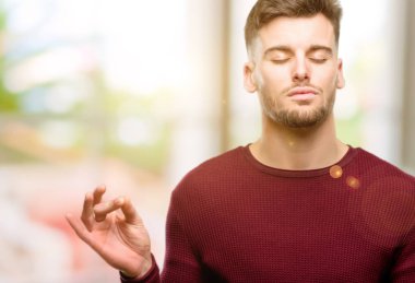 Meditasyon ve gevşeme ifade iki elinle ok işareti jest yapıyor yakışıklı genç