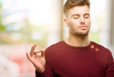 Meditasyon ve gevşeme ifade iki elinle ok işareti jest yapıyor yakışıklı genç