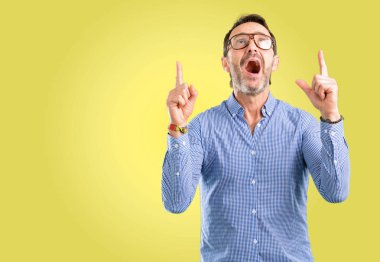 Yakışıklı orta yaş adam mutlu ve yukarı dönük ifade wow jest tezahürat