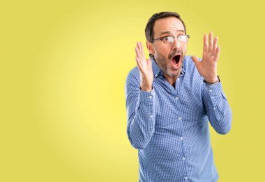 Yakışıklı orta yaş adam stresli kafasına, panik içinde dehşete ellerini tutmak, bağırarak