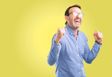 Büyük başarı, güç, enerji ve olumlu duygular ifade yakışıklı orta yaş adam mutlu ve heyecanlı kutluyor zafer. Yeni iş neşeli kutluyor