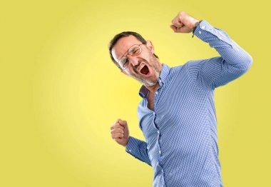 Büyük başarı, güç, enerji ve olumlu duygular ifade yakışıklı orta yaş adam mutlu ve heyecanlı kutluyor zafer. Yeni iş neşeli kutluyor