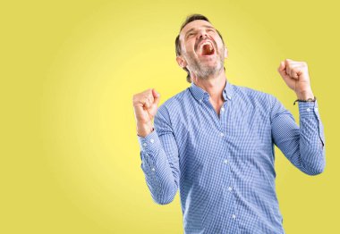 Büyük başarı, güç, enerji ve olumlu duygular ifade yakışıklı orta yaş adam mutlu ve heyecanlı kutluyor zafer. Yeni iş neşeli kutluyor