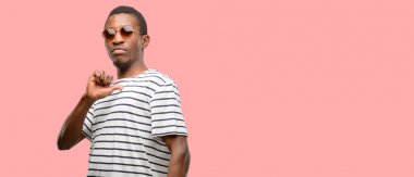 Zafer yüzü ile işaret gurur, heyecanlı ve küstah, güneş gözlüğü takıyor Afrikalı zenci