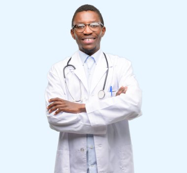 Genç siyah Doktor, kendinden emin ve mutlu bir büyük doğal ile çapraz kolları olan tıbbi profesyonel smile gülüyor