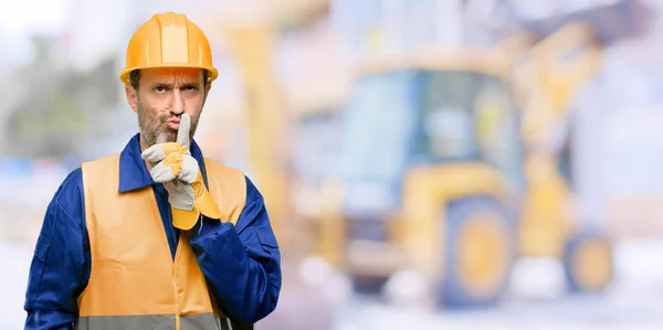 シニア エンジニア男 建設労働者 唇に人差し指を静かに求めます 沈黙と仕事で秘密の概念 — ストック写真