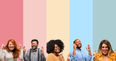 İnsanlar, kadın ve adam şans getirsin diye soran kenetlenmiş parmaklar ile serin grup