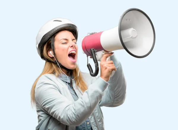 戴着自行车头盔和耳机的年轻女子大声呼喊着话筒 表达成功和积极的概念 营销或销售的想法 — 图库照片